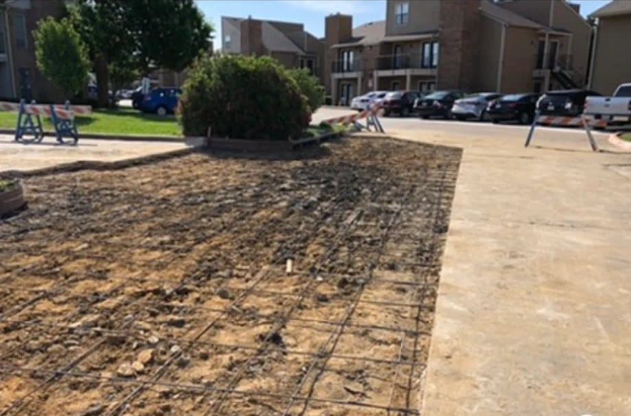 Section of drive removed at an apartment community with welded reinforcement laid on the prepared subgrade